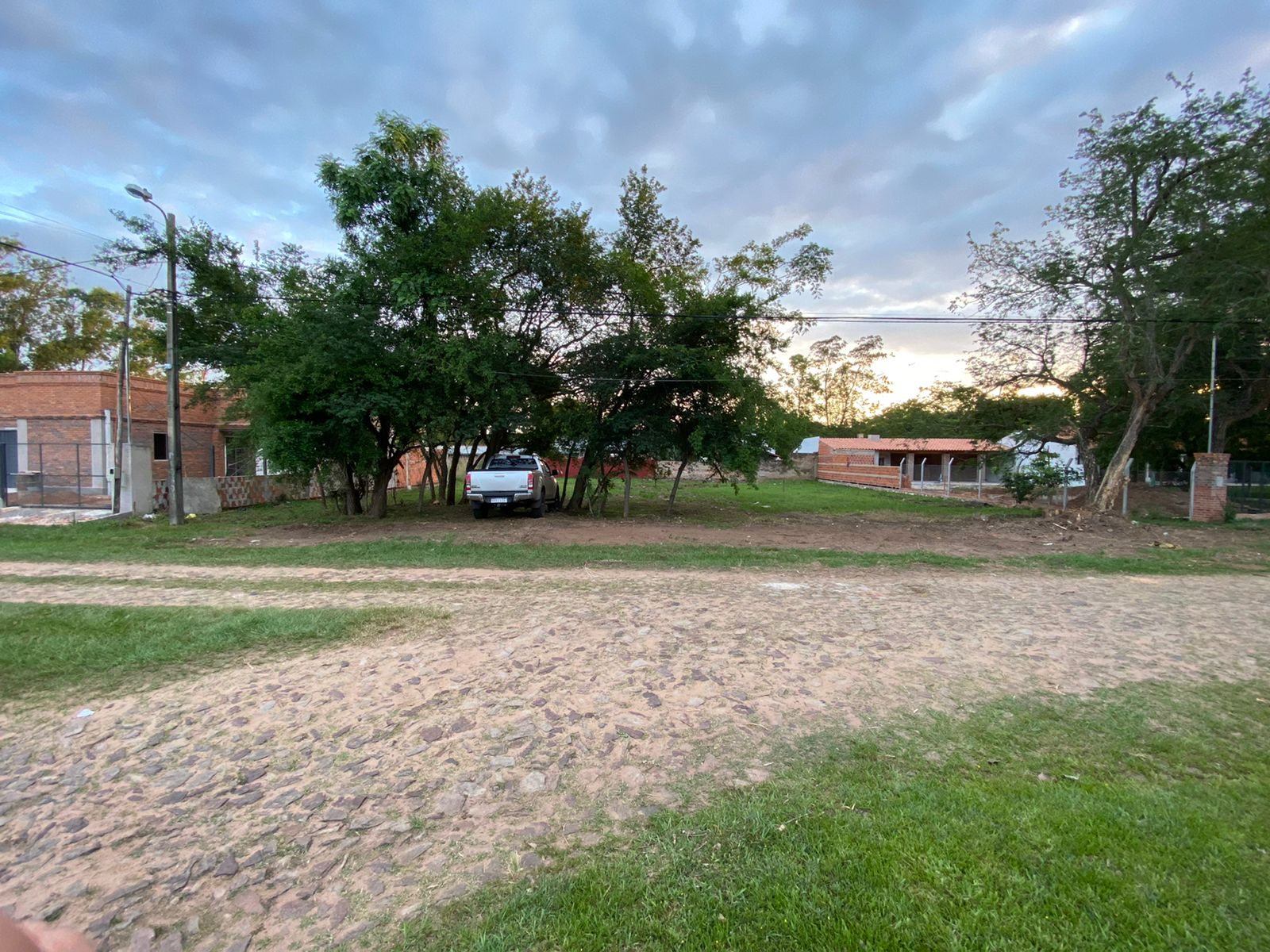 Vista actual del terreno desde la calle, con árboles al frente